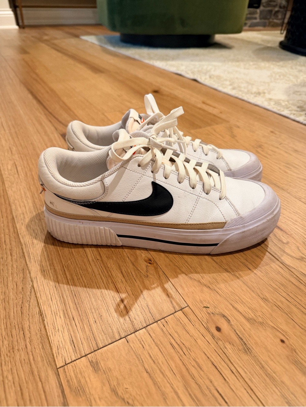 Nike Women's White Sneakers with Black Swoosh and Gold Trim